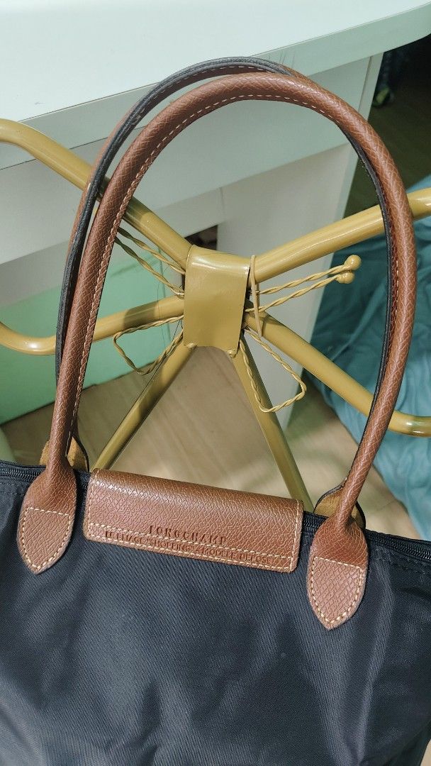Longchamp Le Pliage Tote Bag Black (Category: Luxury Bags & Wallets) located in Antipolo. Submitted by robannrave98496 (Listing ID 1460395291, Image 3). Description: - Classic Longchamp tote bag - Color: Black nylon with brown leather handles and trim - Closure: Zipper - Iconic embossed horse logo on leather flap - Spacious and lightweight design - Ideal for everyday use and travel.
