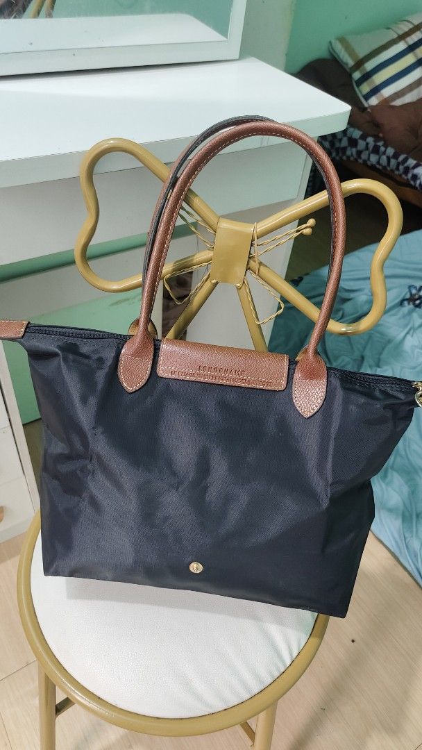Longchamp Le Pliage Tote Bag Black (Category: Luxury Bags & Wallets) located in Antipolo. Submitted by robannrave98496 (Listing ID 1460395291, Image 2). Description: - Classic Longchamp tote bag - Color: Black nylon with brown leather handles and trim - Closure: Zipper - Iconic embossed horse logo on leather flap - Spacious and lightweight design - Ideal for everyday use and travel.