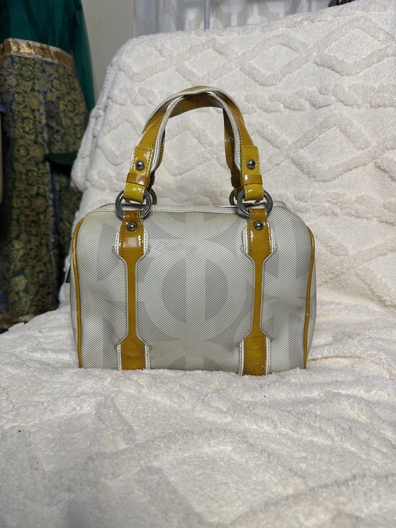 Louis Quatorze (Category: Luxury Bags & Wallets) located in Cauayan City . Submitted by seraphinecyn (Listing ID 1460386419, Image 1). Description: - Cute Coach monogram barrel bag - Off-white canvas with yellow patent leather accents - Compact size, ideal for essentials - Silver hardware - Signs of wear on patent leather trim, particularly bottom corners.
