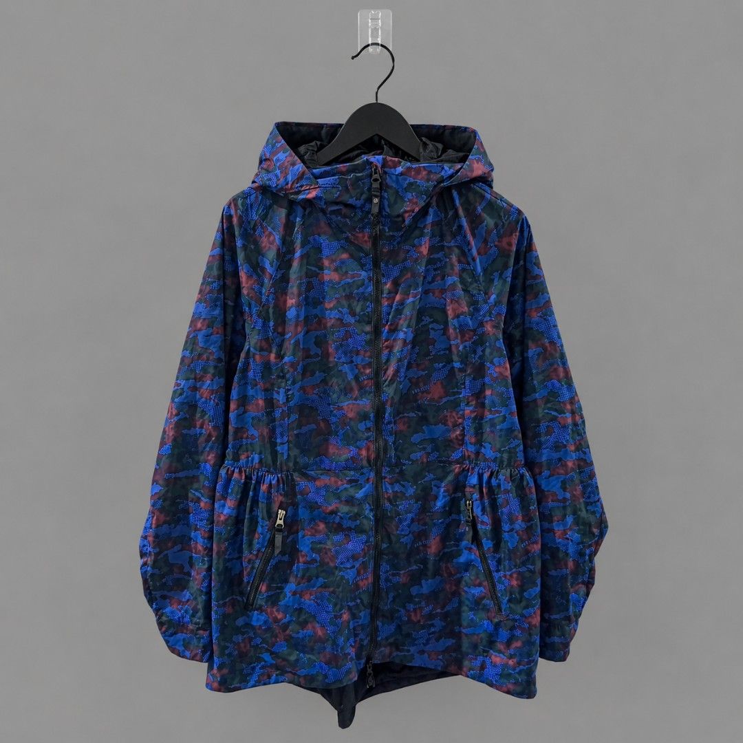 Lululemon Rain For Daze Jacket II (Category: Coats, Jackets and Outerwear) located in Manila. Submitted by pdwainn84681 (Listing ID 1460490553, Image 3). Description: - Lululemon lightweight hooded jacket - Cool camouflage print in blue, red, and green tones - Features zippered pockets on the front - Elasticated waist detail for a comfortable fit - Ideal for layering or protection against light rain - Made in Vietnam.