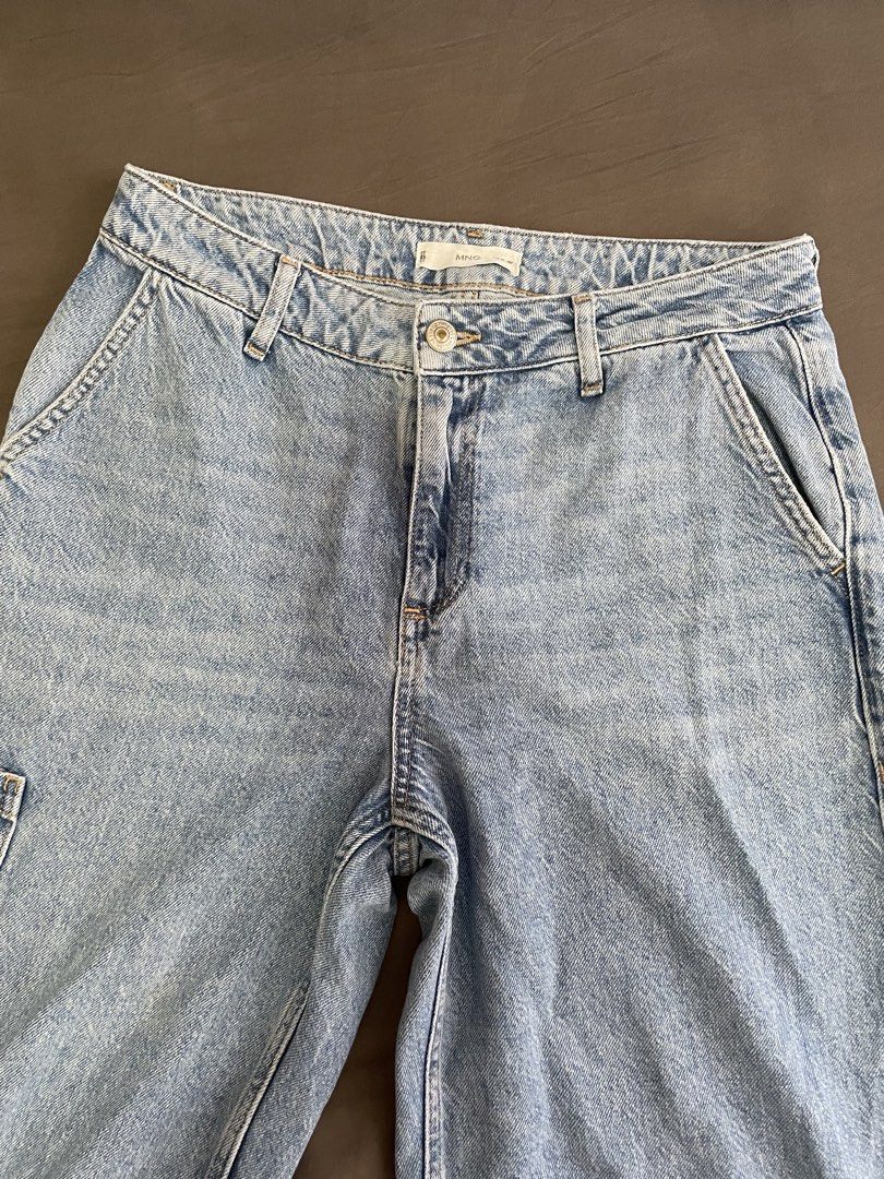 Mango Light Wash Wide Leg Cargo Jeans (Category: Jeans) located in Manila. Submitted by lvdybugs (Listing ID 1460313332, Image 1). Description: - Brand: Mango - Style: Light wash denim jeans - Fit: Wide leg - Features: Cargo pockets on sides, button and zip closure, belt loops - Length: Approximately 38 inches - Size on tag is EUR 32, but can fit upto L - Kindly see last pic for the adjusted length ☺️.