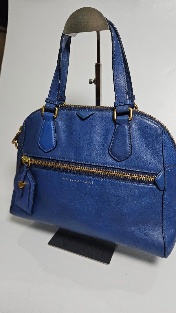 Marc by Marc Jacobs Blue Leather Satchel Handbag (Category: Luxury Bags & Wallets) located in Alfonso. Submitted by jbcamet (Listing ID 1460445189, Image 2). Description: - Marc by Marc Jacobs blue leather satchel - Elegant gold hardware details - Comfortable top handles - Secure zip closure - Includes a small leather tag - Spacious interior, ideal for daily essentials - Perfect everyday bag.