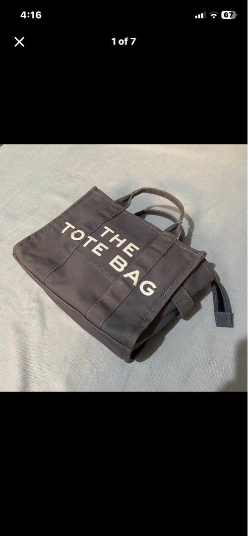 Marc Jacobs The Tote Bag Grey Canvas (Category: Luxury Bags & Wallets) located in Baguio. Submitted by arenzu (Listing ID 1460464617, Image 1). Description: - Authentic Marc Jacobs Grey Canvas Tote Bag - Signature 'The Tote Bag' logo - Small size, ideal for everyday essentials - Zippered main compartment - Interior pocket - Comfortable handles - Adjustable side drawstring closure.