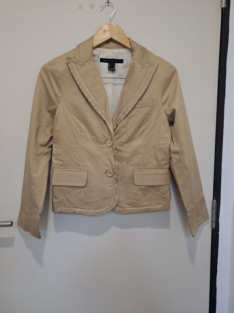 Mark Jacob beige blazer Ex to small (Category: Coats, Jackets and Outerwear) located in Manila. Submitted by joanbalde39643 (Listing ID 1460476989, Image 1). Description: This is a Marc by Marc Jacobs structured peak-lapel blazer in a classic khaki/beige hue. It features unique layered grosgrain piping along the prominent lapel edges, a welt chest pocket, a standard size 2 fit, and a subtle polka-dot interior lining..