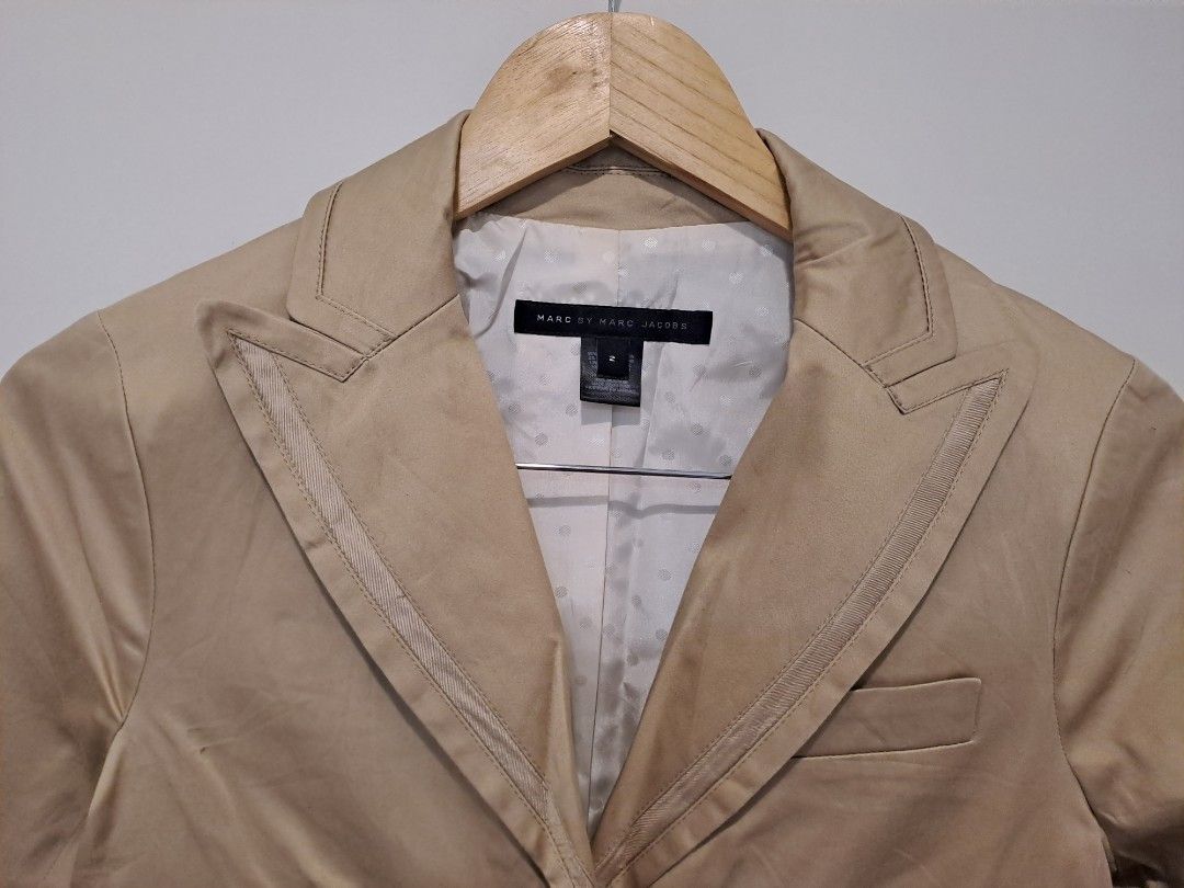 Mark Jacob beige blazer Ex to small (Category: Coats, Jackets and Outerwear) located in Manila. Submitted by joanbalde39643 (Listing ID 1460476989, Image 2). Description: This is a Marc by Marc Jacobs structured peak-lapel blazer in a classic khaki/beige hue. It features unique layered grosgrain piping along the prominent lapel edges, a welt chest pocket, a standard size 2 fit, and a subtle polka-dot interior lining..