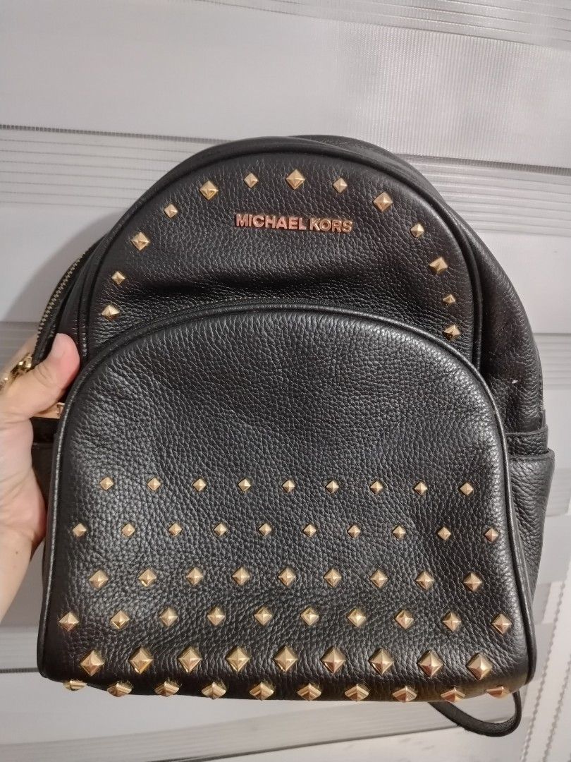 Michael Kors Black Leather Studded Backpack (Category: Backpacks) located in Santa Maria. Submitted by gratefulforever (Listing ID 1460488675, Image 1). Description: - Genuine Michael Kors black leather backpack - Eye-catching gold-tone studs on front pocket and body - Secure zipper closure with branded pulls - Adjustable shoulder straps for comfort - Ideal for everyday errands or your next adventure.