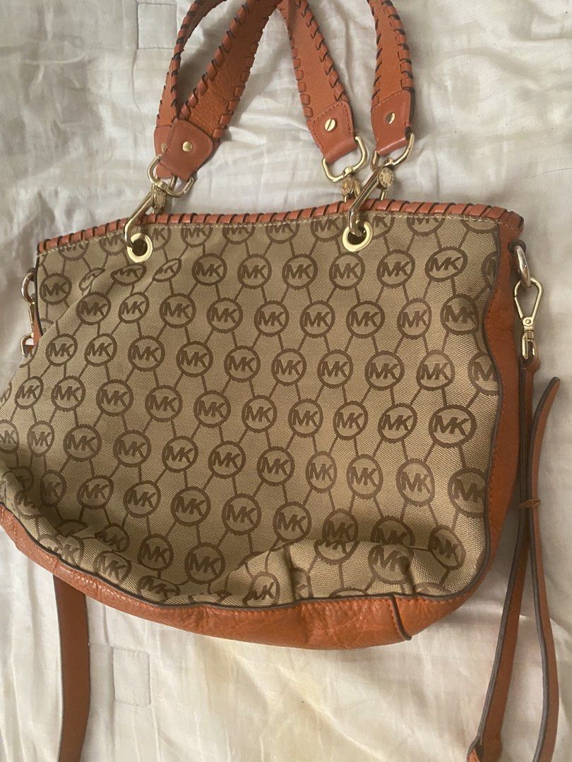 Michael Kors Monogram Canvas Leather Trim Shoulder Bag (Category: Luxury Bags & Wallets) located in Santa Rosa. Submitted by intra_life4life (Listing ID 1460331383, Image 1). Description: - Michael Kors shoulder bag - Tan canvas with signature MK monogram print - Vibrant orange leather trim - Stylish braided handles - Elegant gold hardware - Includes iconic MK charm and tassel detail - Comes with an adjustable shoulder strap - Ideal for daily use
