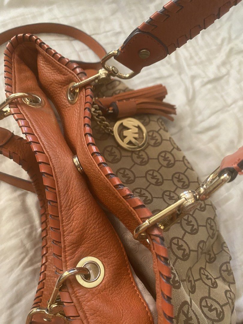 Michael Kors Monogram Canvas Leather Trim Shoulder Bag (Category: Luxury Bags & Wallets) located in Santa Rosa. Submitted by intra_life4life (Listing ID 1460331383, Image 2). Description: - Michael Kors shoulder bag - Tan canvas with signature MK monogram print - Vibrant orange leather trim - Stylish braided handles - Elegant gold hardware - Includes iconic MK charm and tassel detail - Comes with an adjustable shoulder strap - Ideal for daily use