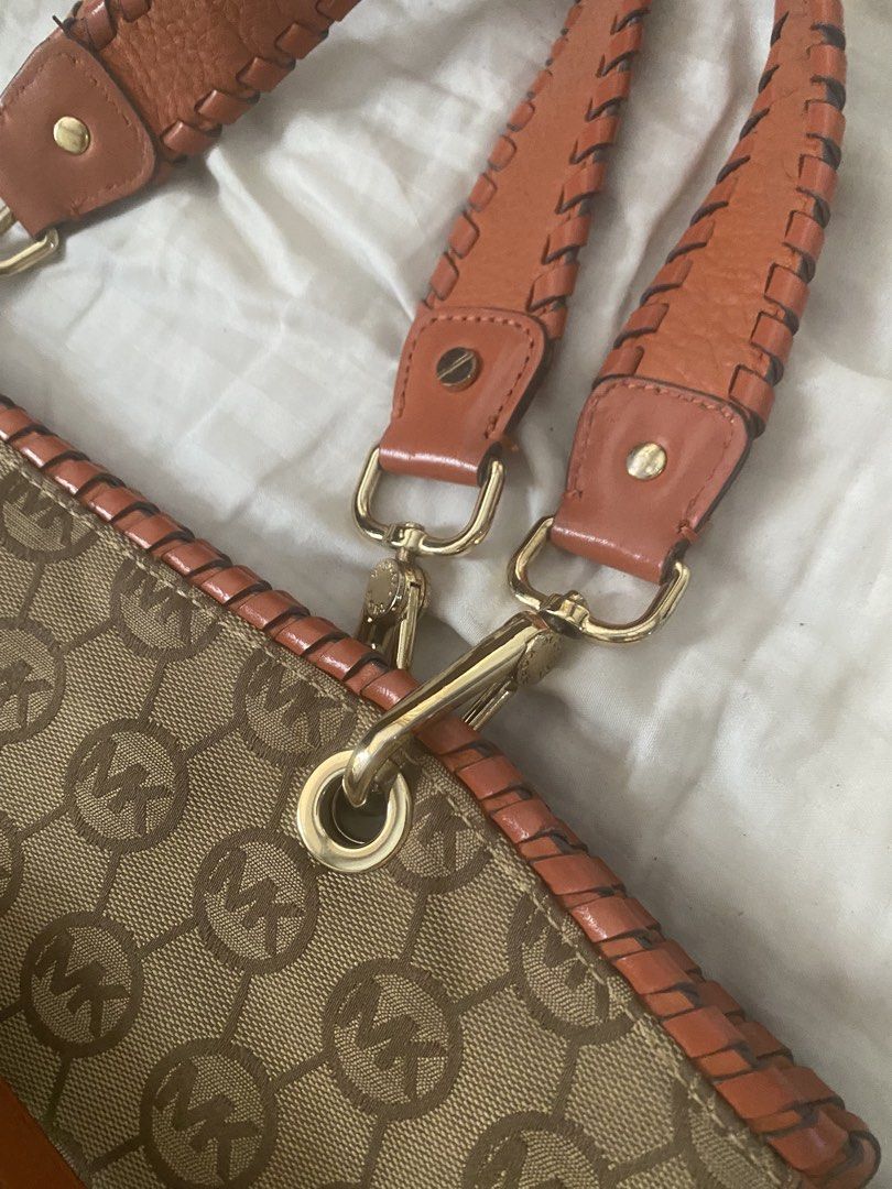 Michael Kors Monogram Canvas Leather Trim Shoulder Bag (Category: Luxury Bags & Wallets) located in Santa Rosa. Submitted by intra_life4life (Listing ID 1460331383, Image 3). Description: - Michael Kors shoulder bag - Tan canvas with signature MK monogram print - Vibrant orange leather trim - Stylish braided handles - Elegant gold hardware - Includes iconic MK charm and tassel detail - Comes with an adjustable shoulder strap - Ideal for daily use
