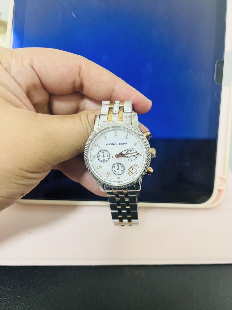 Michael Kors Two-Tone Chronograph Watch (Category: Luxury Watches) located in Manila. Submitted by vineshrubs75 (Listing ID 1460325340, Image 2). Description: - Like new Michael Kors chronograph watch -Mother pearl color - Two-tone stainless steel case and bracelet - Crystal hour markers for a touch of sparkle - Features a date display - Reliable quartz movement - A classic, versatile accessory to elevate any outfit - Price is negotiable - Please