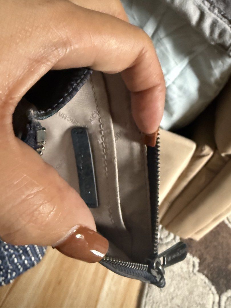 Michael Kors Wallet (Category: Wallets & Card holders) located in Taguig. Submitted by ayieabolencia (Listing ID 1460459046, Image 1). Description: - Authentic Michael Kors wallet - Stylish dark blue exterior with textured pattern - Secure zipper closure - Interior features multiple card slots and a small pocket - Clean and well-maintained interior - Ideal for keeping your cards and cash neatly organized.