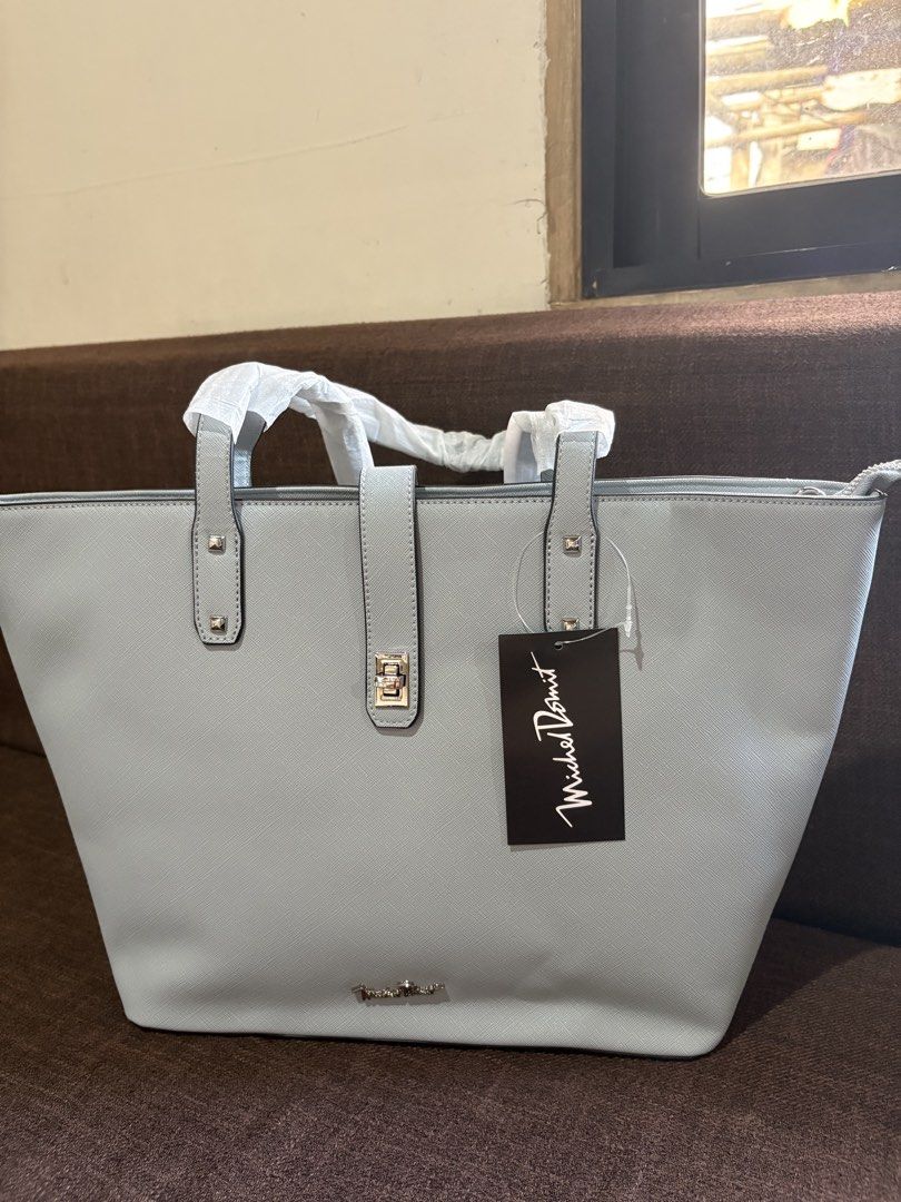 Mikeal domit (Category: Tote Bags) located in Pototan. Submitted by tres_190725 (Listing ID 1460435230, Image 3). Description: The image features a light grey or baby blue Saffiano leather structured tote bag with a matching central strap and turn-lock detail, bearing a tag from Michel Domit.