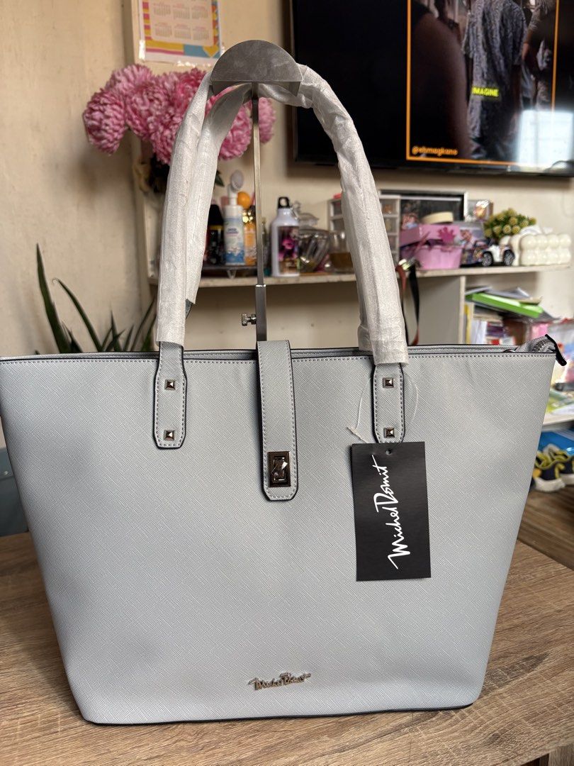 Mikeal domit (Category: Tote Bags) located in Pototan. Submitted by tres_190725 (Listing ID 1460435230, Image 1). Description: The image features a light grey or baby blue Saffiano leather structured tote bag with a matching central strap and turn-lock detail, bearing a tag from Michel Domit.