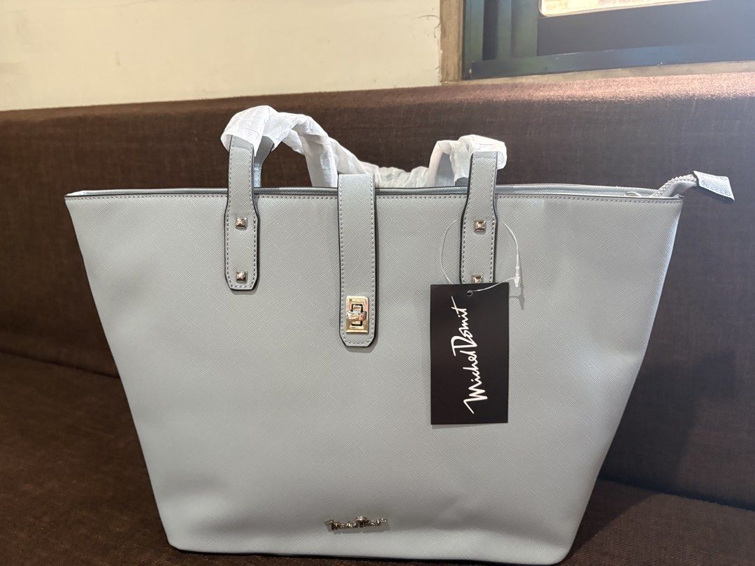 Mikeal domit (Category: Tote Bags) located in Pototan. Submitted by tres_190725 (Listing ID 1460435230, Image 2). Description: The image features a light grey or baby blue Saffiano leather structured tote bag with a matching central strap and turn-lock detail, bearing a tag from Michel Domit.