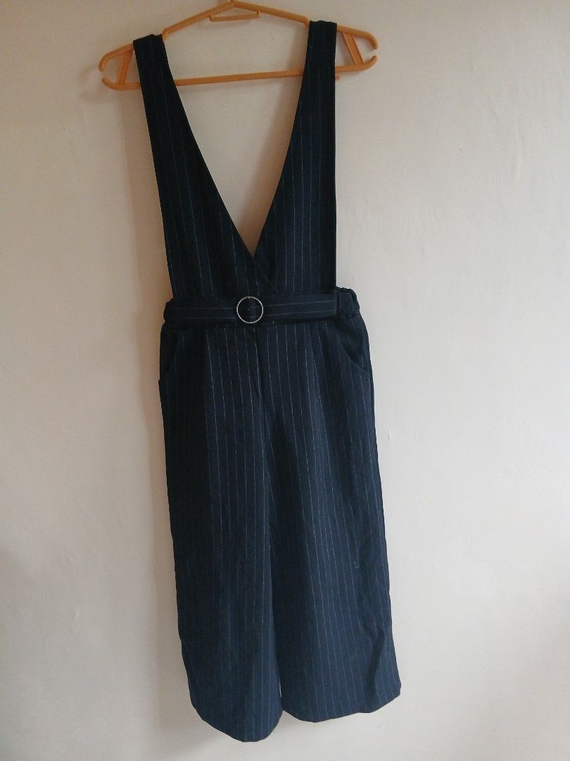 Navy Pinstripe Pinafore Pants with Ring Detail (Category: Jeans) located in Tayabas. Submitted by ahrcelllego (Listing ID 1460319607, Image 1). Description: - Chic navy blue pinafore pants - Classic white pinstripe pattern - Stylish wide leg design - Unique metal ring detail on front strap - Versatile for casual or dressed-up outfits - Effortlessly pairs with any top.