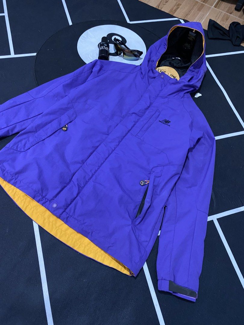 New Balance Purple Hooded Jacket (Category: Coats, Jackets and Outerwear) located in Cateel. Submitted by khan.find_ (Listing ID 1460329295, Image 2). Description: - Purple New Balance jacket with hood - Yellow lining inside - Chest pocket and two side pockets - Elasticated cuffs - Lightweight and easy to pack - Ideal for outdoor activities or casual wear.