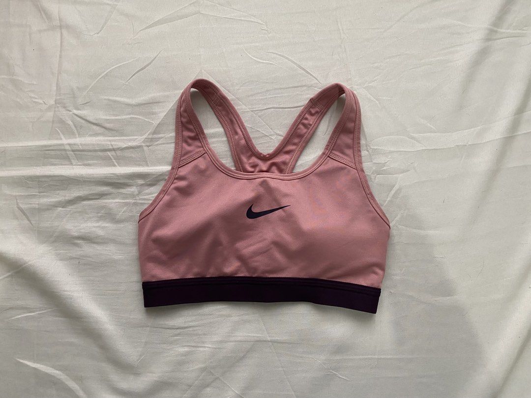 Nike Pink Sports Bra (Category: Activewear) located in Batangas. Submitted by shop.aalley (Listing ID 1460332645, Image 1). Description: - Pink Nike sports bra - Dark purple band - Racerback style - Comfortable and supportive - Features Nike logo on the front - Ideal for workouts and everyday wear.
