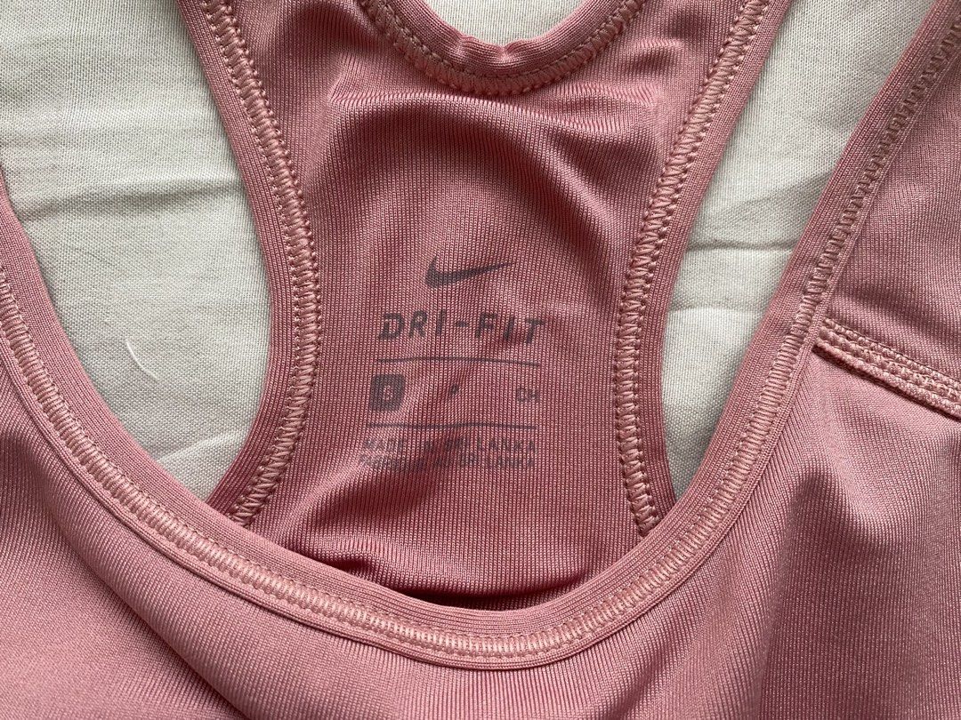 Nike Pink Sports Bra (Category: Activewear) located in Batangas. Submitted by shop.aalley (Listing ID 1460332645, Image 2). Description: - Pink Nike sports bra - Dark purple band - Racerback style - Comfortable and supportive - Features Nike logo on the front - Ideal for workouts and everyday wear.