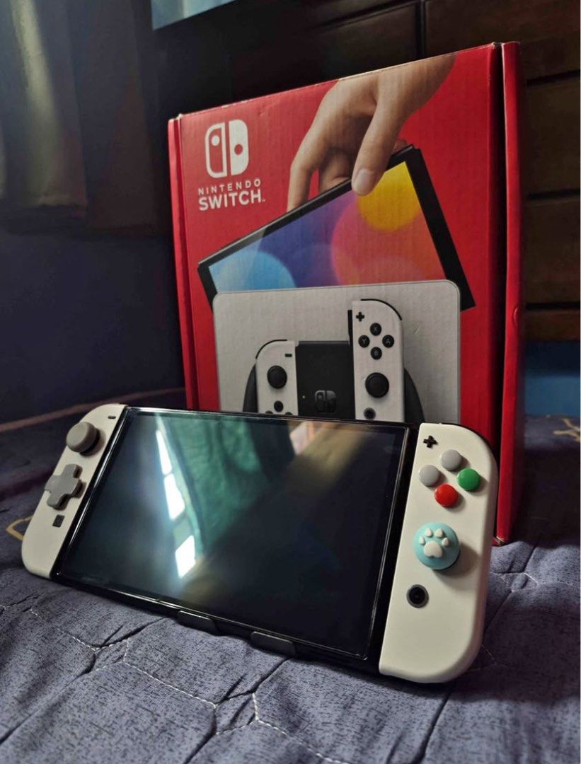 Nintendo Switch OLED (Category: Nintendo) located in Makati City. Submitted by stuhxoo (Listing ID 1460464143, Image 1). Description: Nintendo Switch OLED White Switch #2 Inclusions: - Box - Screen Protector - Dobe Joy-Con Grip (White) - Joy-Con Grip - Dock - HDMI Cable - Charger - Joycon Straps .