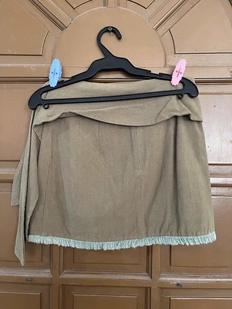 Olive Green Fringed Wrap Mini Skirt (Category: Skirts) located in Manila. Submitted by ellesmr122 (Listing ID 1460323220, Image 2). Description: - Olive green mini skirt - Wrap style with side tie detail - Frayed fringe hem - Estimated size S or M - Ideal for casual outings.