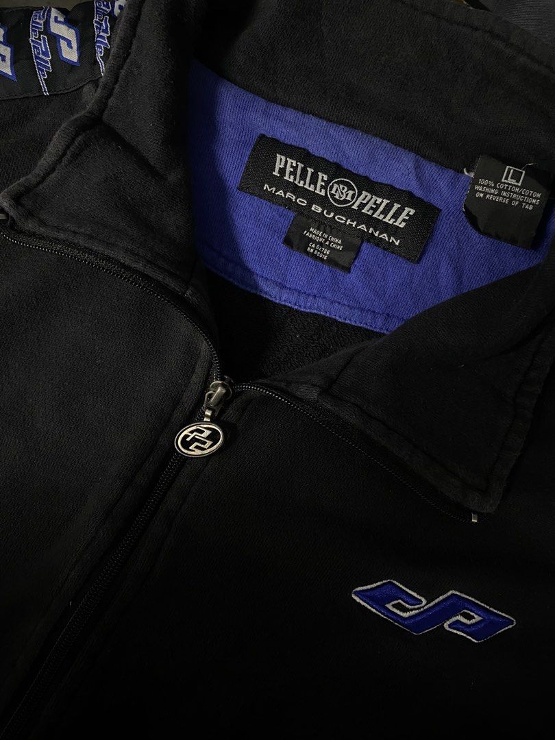 Pelle Pelle Marc Buchanan Track Jacket (Category: Coats, Jackets and Outerwear) located in Santa Maria. Submitted by saintarchive316 (Listing ID 1460431122, Image 2). Description: - Black Pelle Pelle track jacket - Blue accents - Pelle Pelle logo on chest - Repeating logo pattern on sleeves - Full zip closure - 100% Cotton - Size L.