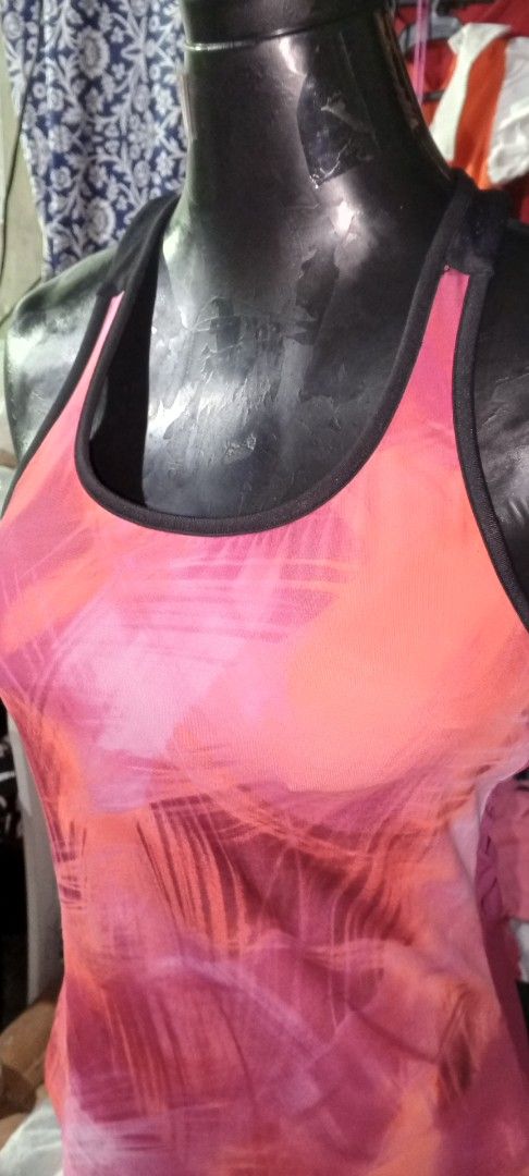 Pink Orange Abstract Print Racerback Tank Top (Category: Sleeveless) located in Manila. Submitted by ezekislacl02490 (Listing ID 1460422773, Image 2). Description: - Vibrant pink and orange abstract print - Racerback style for comfort and mobility - Lightweight and breathable fabric - Solid pink ribbed back panel for added support - Ideal for workouts, gym sessions, or casual outings - Easily pairs with leggings, shorts, or athletic bottoms.