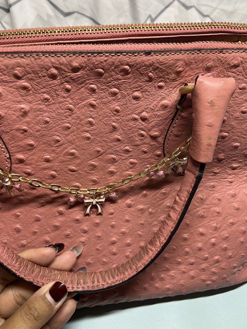 Pink Ostrich Embossed Handbag with Bow Charm (Category: Luxury Bags & Wallets) located in Liloan. Submitted by sakurumifinds2809 (Listing ID 1460355692, Image 3). Description: - Adorable pink handbag with a unique ostrich-like texture. - Elegant gold hardware. - Secure top zip closure. - Spacious interior with multiple compartments for organization. - Handles show some signs of wear. - Versatile for everyday errands or a stylish night out. -Can f