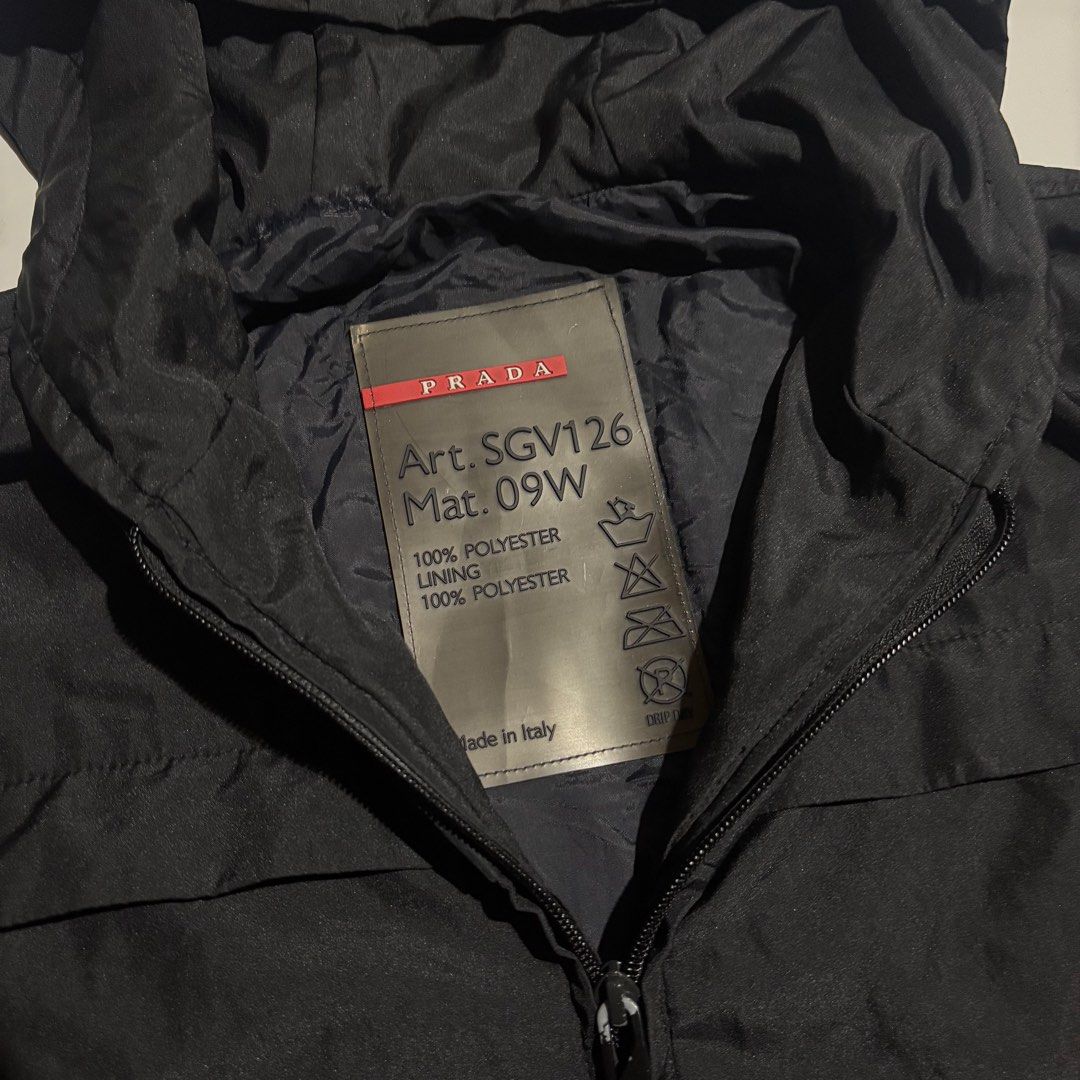 Prada Black Hooded Jacket Art. SGV126 (Category: Coats, Jackets and Outerwear) located in Cebu City. Submitted by kidfrom6000 (Listing ID 1460504318, Image 3). Description: - Authentic Prada hooded jacket - Made in Italy - 100% Polyester - Zip closure with pockets - Iconic Prada logo on the back - Red Prada tag on the sleeve - Ideal for everyday wear - Dimes are avail in the pics - cebu city - price + sf.