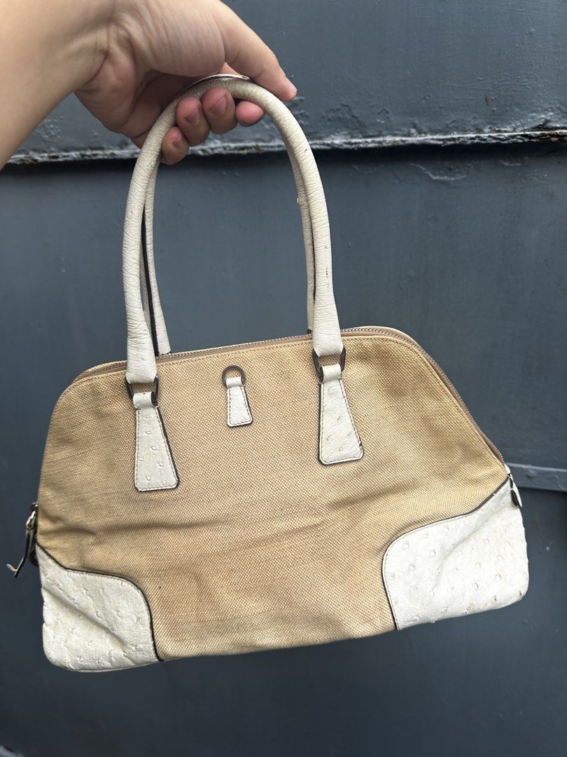 Prada Canvas Ostrich Trimmed Handbag (Category: Luxury Bags & Wallets) located in Quezon City. Submitted by la.deals (Listing ID 1460346070, Image 2). Description: - Authentic Prada handbag - Beige and white canvas body - Ostrich leather trim - Shows some marks and wear on canvas and handles - Zippers are in good working condition - Scuffs present on the bottom of the bag - Overall, a nice pre-owned bag.