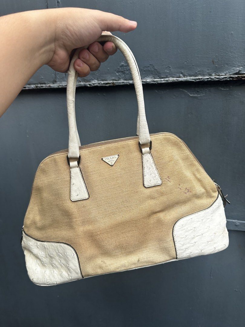 Prada Canvas Ostrich Trimmed Handbag (Category: Luxury Bags & Wallets) located in Quezon City. Submitted by la.deals (Listing ID 1460346070, Image 1). Description: - Authentic Prada handbag - Beige and white canvas body - Ostrich leather trim - Shows some marks and wear on canvas and handles - Zippers are in good working condition - Scuffs present on the bottom of the bag - Overall, a nice pre-owned bag.