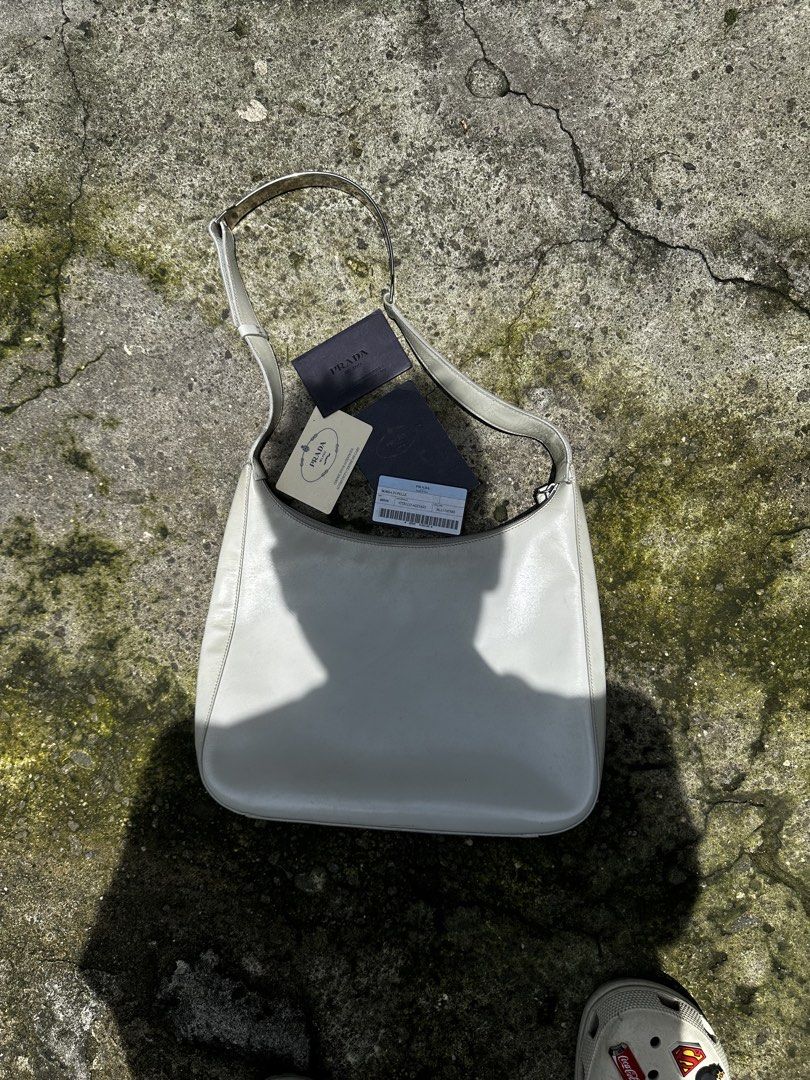 Prada cleo shoulder bag (Category: Luxury Bags & Wallets) located in Quezon City. Submitted by la.deals (Listing ID 1460365417, Image 1). Description: - Authentic Prada shoulder bag - Color: Light grey leather - Includes authenticity cards - Unique buckle detail on strap - Ideal for everyday use.