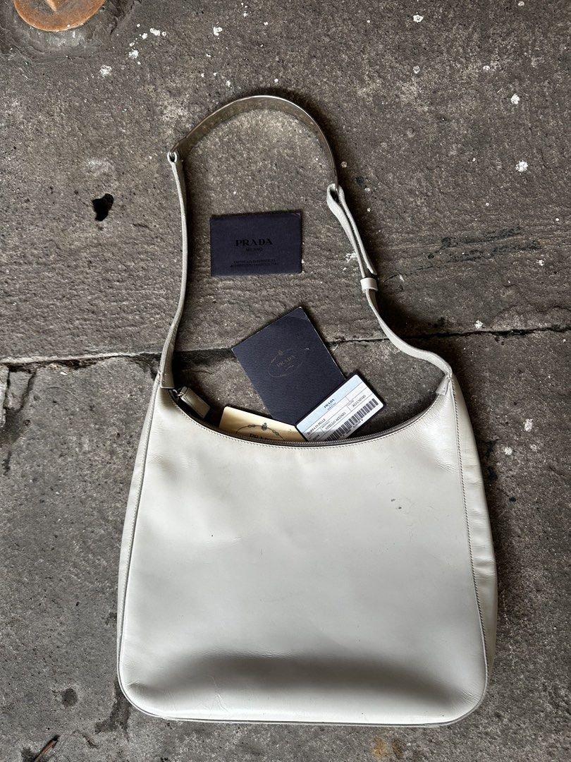 Prada cleo shoulder bag (Category: Luxury Bags & Wallets) located in Quezon City. Submitted by la.deals (Listing ID 1460365417, Image 3). Description: - Authentic Prada shoulder bag - Color: Light grey leather - Includes authenticity cards - Unique buckle detail on strap - Ideal for everyday use.