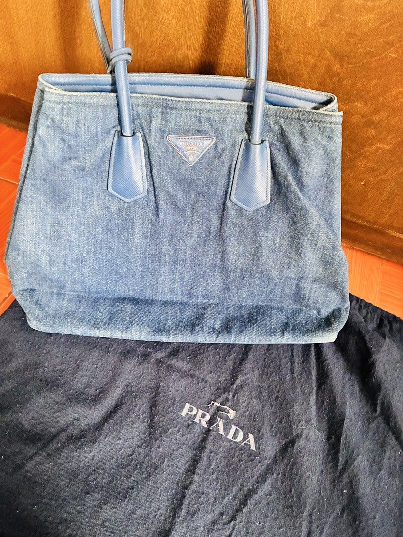 STEAL! Prada Denim Tote Bag (Category: Luxury Bags & Wallets) located in Angeles City. Submitted by meandshopping (Listing ID 1460314287, Image 2). Description: - Authentic Prada tote bag - Made from durable denim with blue leather accents - Comes with original dust bag - Interior features a zippered pocket and a separate pouch - Ideal for everyday use - Spacious enough for all your essentials - No major or noticeable flaws, just signs of use..