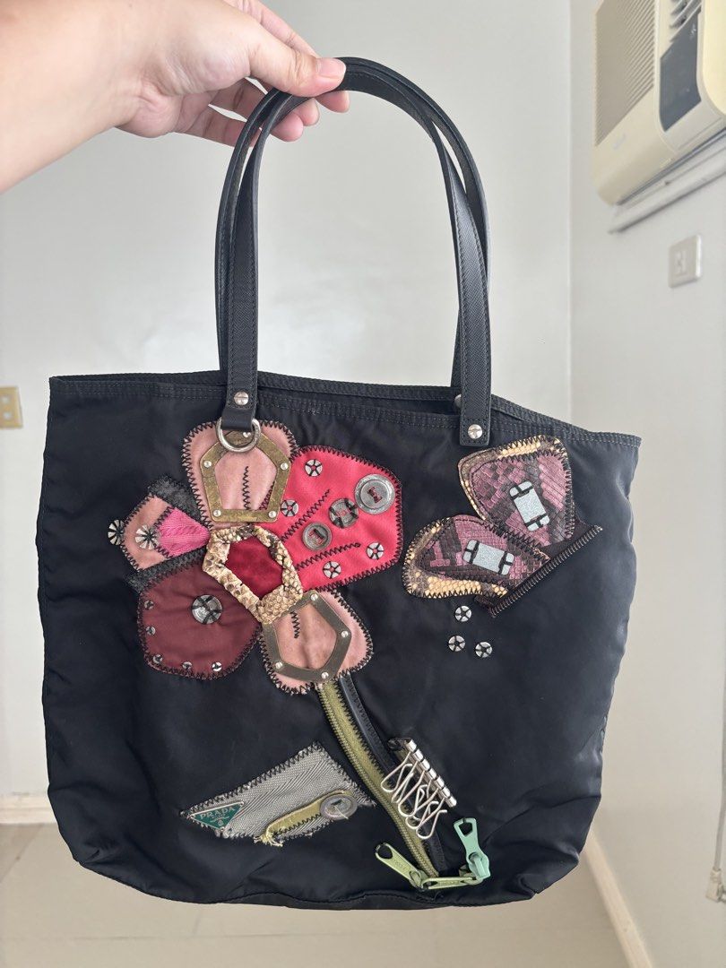 Prada Tessuto Flower Nylon Tote Bag (Category: Luxury Bags & Wallets) located in Manila. Submitted by notjaneahe05680 (Listing ID 1460461735, Image 1). Description: - Authentic Black Prada Nylon Tote Bag No issues, unli photo and check if you want. Used once or twice lang then nakastock nalang. Pm me your offer! Loc: Pangasinan.