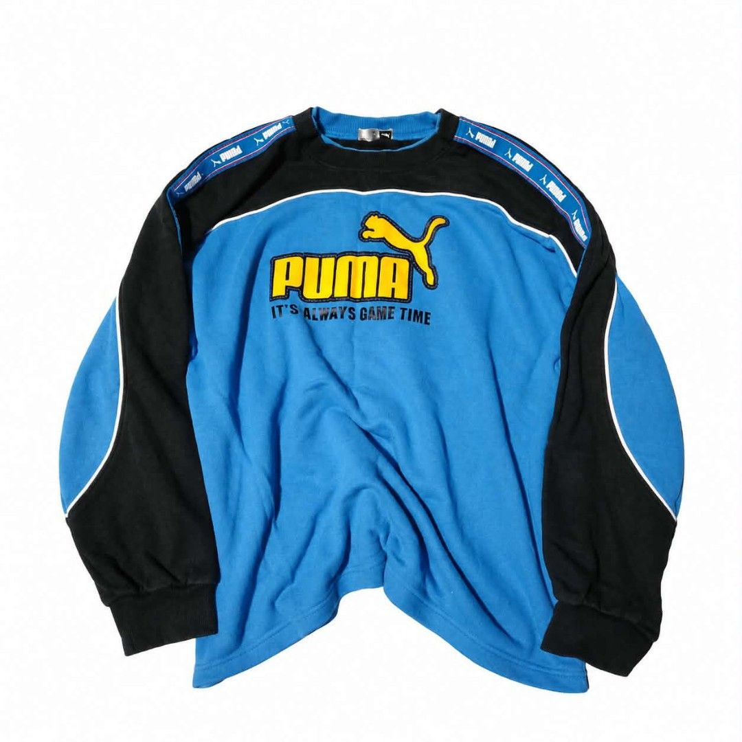Puma Sweatshirt Blue Black "It's Always Game Time" (Category: Coats, Jackets and Outerwear) located in Manila. Submitted by chieezz (Listing ID 1460459200, Image 1). Description: - Bright blue Puma sweatshirt with black sleeves and shoulders. - Features iconic Puma logo and "It's Always Game Time" text. - Puma branding tape detail along the shoulders. - Ideal for a stylish and comfortable casual look..