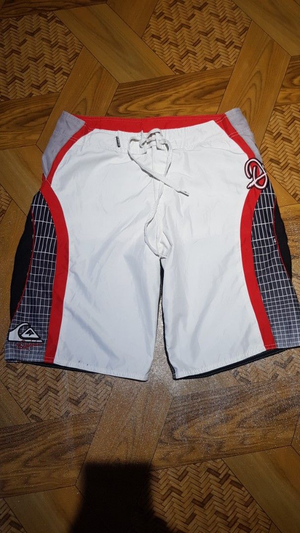 Quiksilver Board Shorts White Red Black Grid Pattern (Category: Swim Trunks & Board Shorts) located in Manila. Submitted by nice430 (Listing ID 1460319968, Image 1). Description: - Quiksilver board shorts - White with red and black grid accents on the sides - Drawstring waist for adjustable fit - Perfect for swimming, surfing, or lounging - In good, pre-loved condition.
