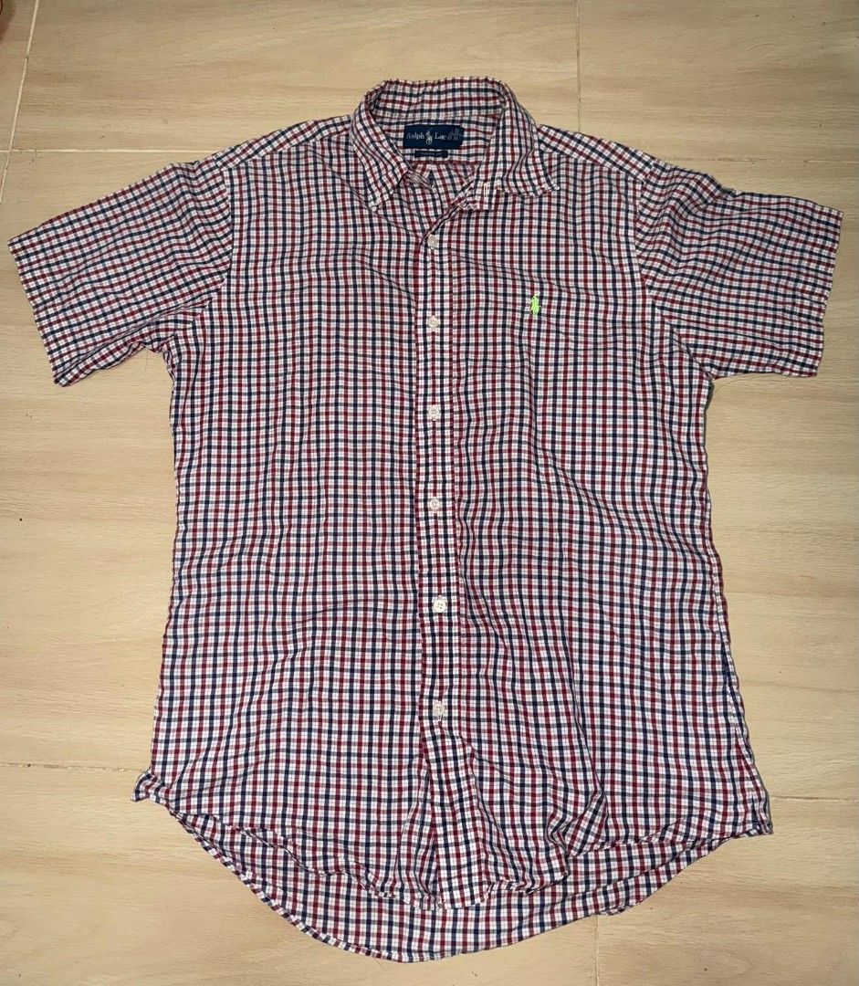 Ralph Lauren Gingham Short Sleeve Shirt (Category: Tshirts & Polo Shirts ) located in Cainta. Submitted by hermosooo (Listing ID 1460432101, Image 1). Description: - Classic Ralph Lauren short sleeve shirt - Red, white, and blue gingham pattern - Iconic embroidered polo player logo on chest - Button-down style - Perfect for casual wear.