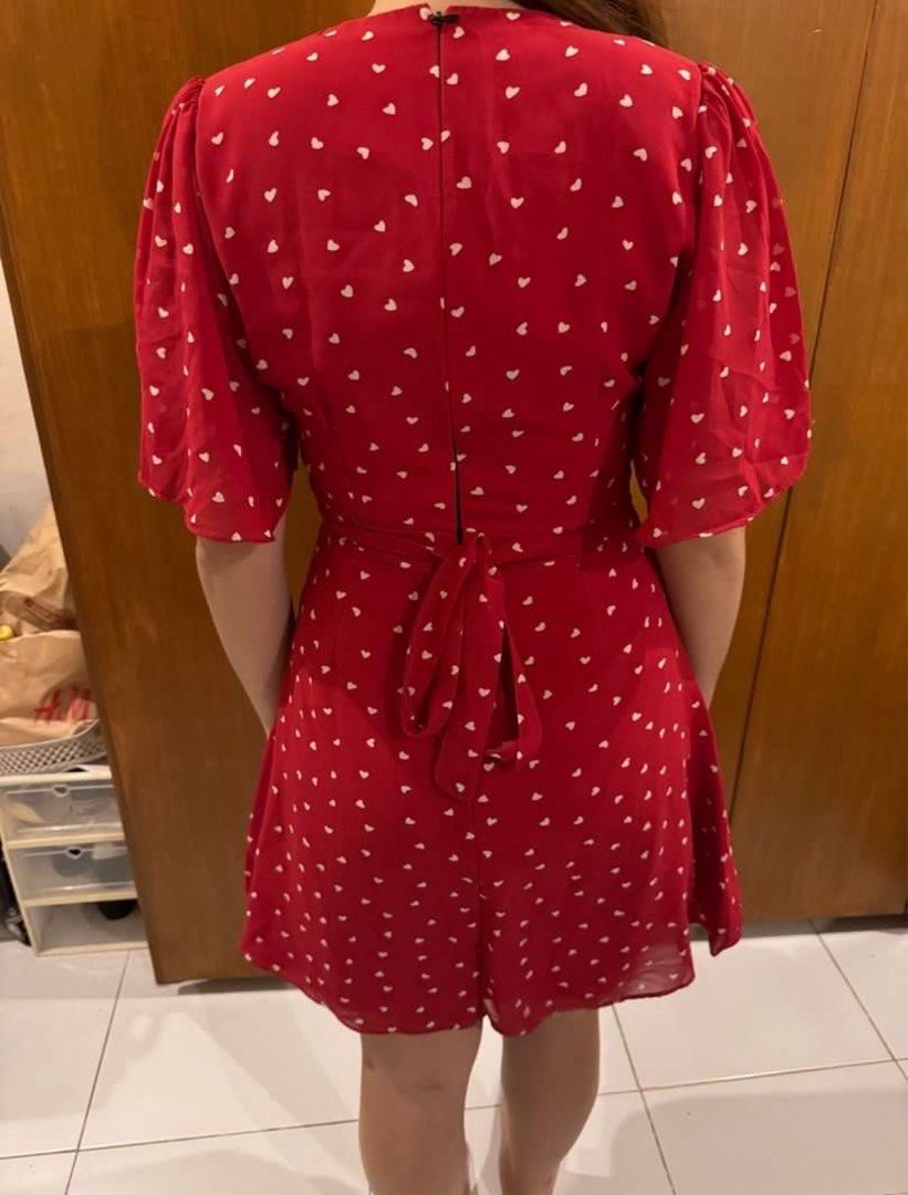 Red Heart Print Mini Dress with Flutter Sleeves (Category: Dresses) located in Manila. Submitted by carlanunez_442 (Listing ID 1460494573, Image 2). Description: - Adorable red mini dress with a charming white heart print. - Flattering V-neckline and delicate flutter sleeves. - Cinched waist with an adjustable tie-back for a customized fit. - Versatile for casual outings, dates, or everyday wear. - Effortless to style and comfortable for all-day 