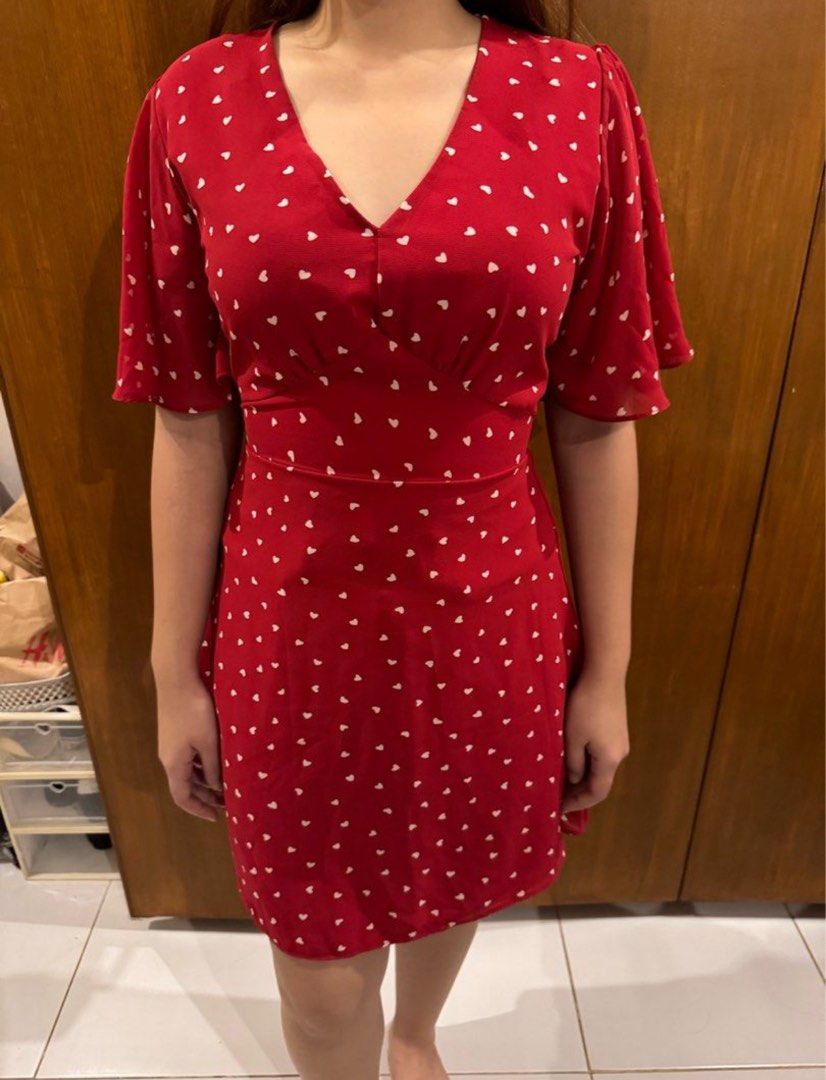Red Heart Print Mini Dress with Flutter Sleeves (Category: Dresses) located in Manila. Submitted by carlanunez_442 (Listing ID 1460494573, Image 1). Description: - Adorable red mini dress with a charming white heart print. - Flattering V-neckline and delicate flutter sleeves. - Cinched waist with an adjustable tie-back for a customized fit. - Versatile for casual outings, dates, or everyday wear. - Effortless to style and comfortable for all-day 