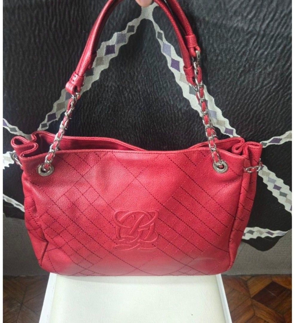 Red Quatorze Leather Quilted Shoulder Bag (Category: Other Accessories) located in Quezon City. Submitted by affordabags_cd (Listing ID 1460425082, Image 2). Description: - Genuine red leather shoulder bag - Elegant quilted pattern - Prominent 'LQ' logo on the front - Stylish silver chain detailing on straps - Interior with branded tag and patterned lining - Protective studs on the bottom - Spacious for daily essentials.