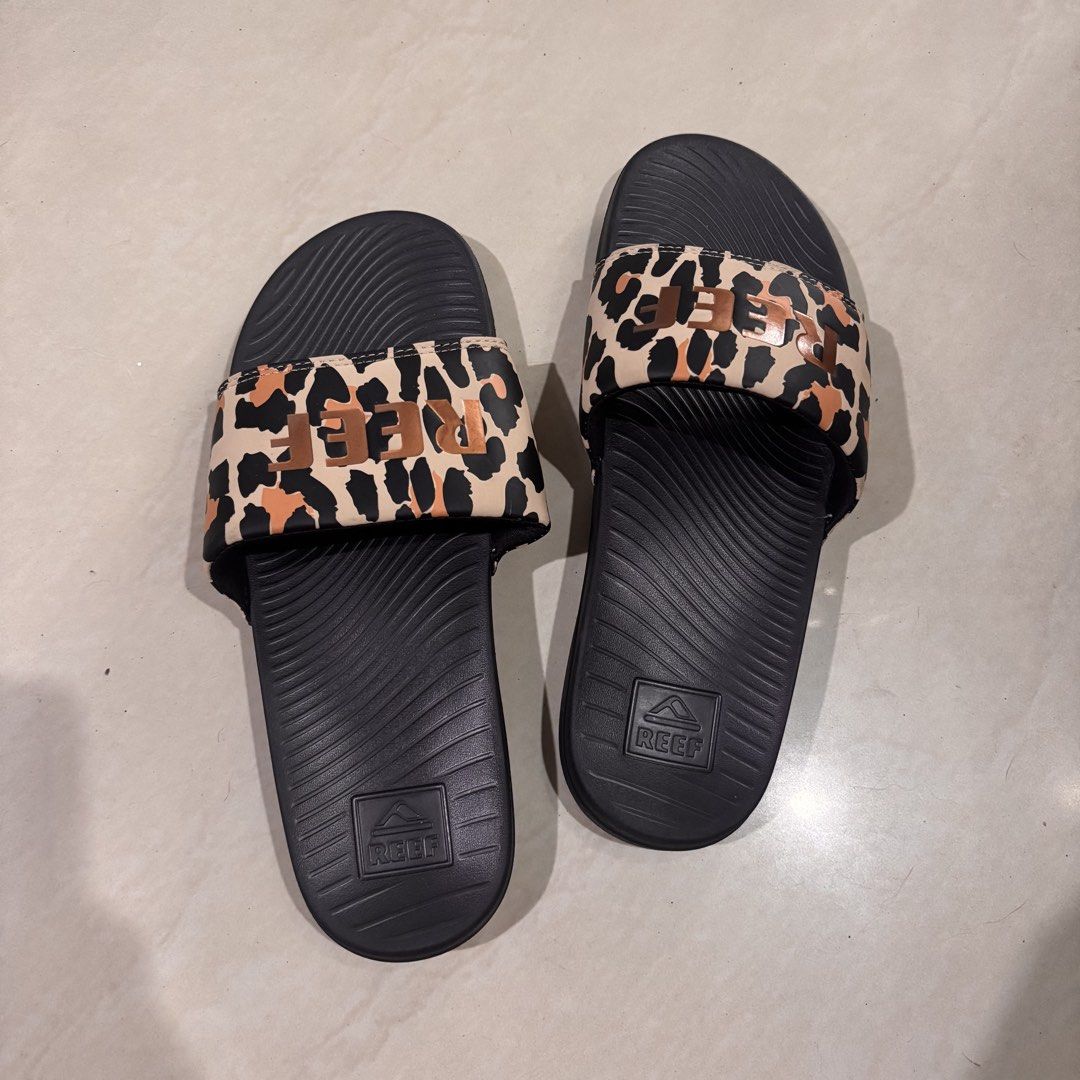 Reef Leopard Print Slides Sandals (Category: Slippers and slides) located in Manila. Submitted by jc_bodega (Listing ID 1460335831, Image 2). Description: Negotiable! Message me 🛍️ - Leopard print black Reef slides - Wavy sole pattern + padding - Good for outdoor activities, beach, swims, etc. - Authentic Reef branding visible on sole and strap - Wear: Never been worn, no tag.