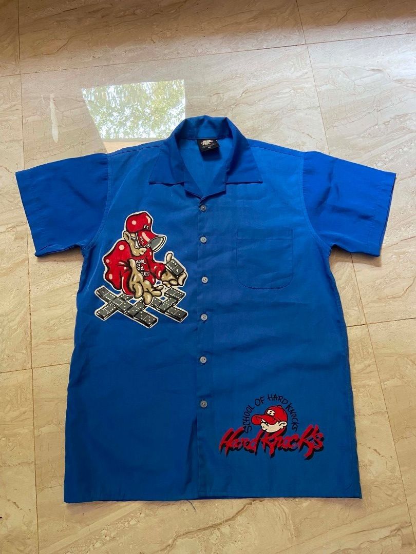 SCHOOL OF HARD KNOCKS Y2K POLO (Category: Tshirts & Polo Shirts ) located in Manila. Submitted by lilsintenel (Listing ID 1460399221, Image 1). Description: - Cool blue short sleeve button up shirt - 20x 27 - Features a fun graphic print on the front and back - Includes a convenient chest pocket - Ideal for casual everyday wear.
