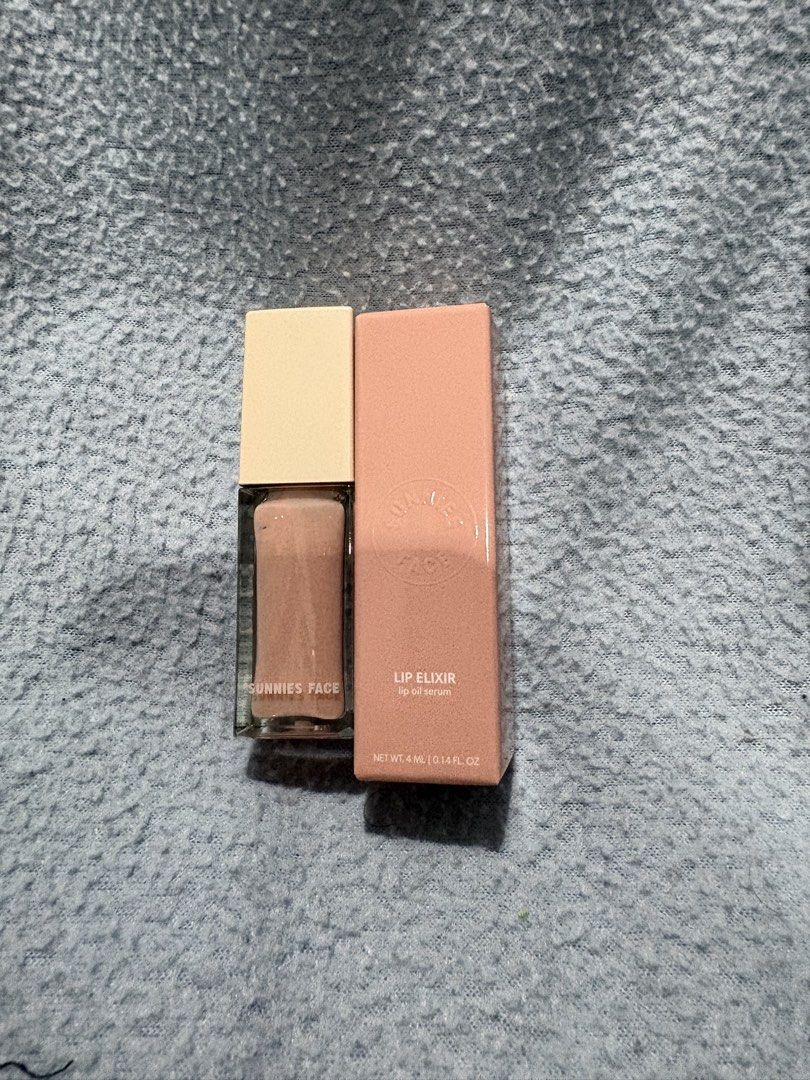 Sunnies Face Lip Elixir Lip Oil Serum (Category: Makeup) located in Quezon City. Submitted by lai.espina (Listing ID 1460460946, Image 1). Description: - Sunnies Face Lip Elixir - Hydrating lip oil serum - Comes in a glass bottle with a light beige cap - Packaged in a peach-colored box - Net weight: 4ml / 0.14 fl oz.
