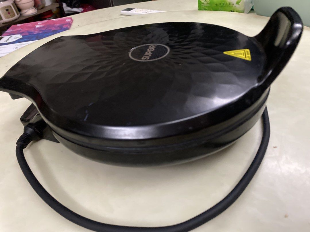 Supor Black Electric Pizza Maker (Category: Other Kitchenware & Tableware) located in Imus. Submitted by 9teen.87 (Listing ID 1460470132, Image 1). Description: - Brand: Supor - Color: Black - Features: Textured lid, handle, attached power cord - Ideal for: Making delicious waffles pizza pancake at home.
