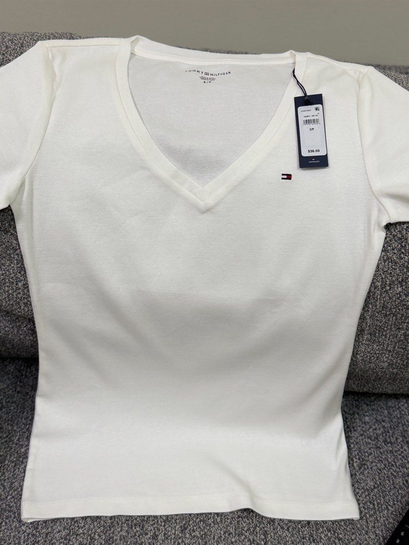 Tommy Hilfiger Basic White V-Neck T-Shirt (Category: Shirts) located in Pasig City. Submitted by shopwithelle__ (Listing ID 1460491024, Image 3). Description: - Classic white V-neck t-shirt - Brand: Tommy Hilfiger - Material: Soft cotton - Detail: Small logo on the chest - Size: S/P (Small/Petite) (fits upto med) - Versatile basic for any outfit.