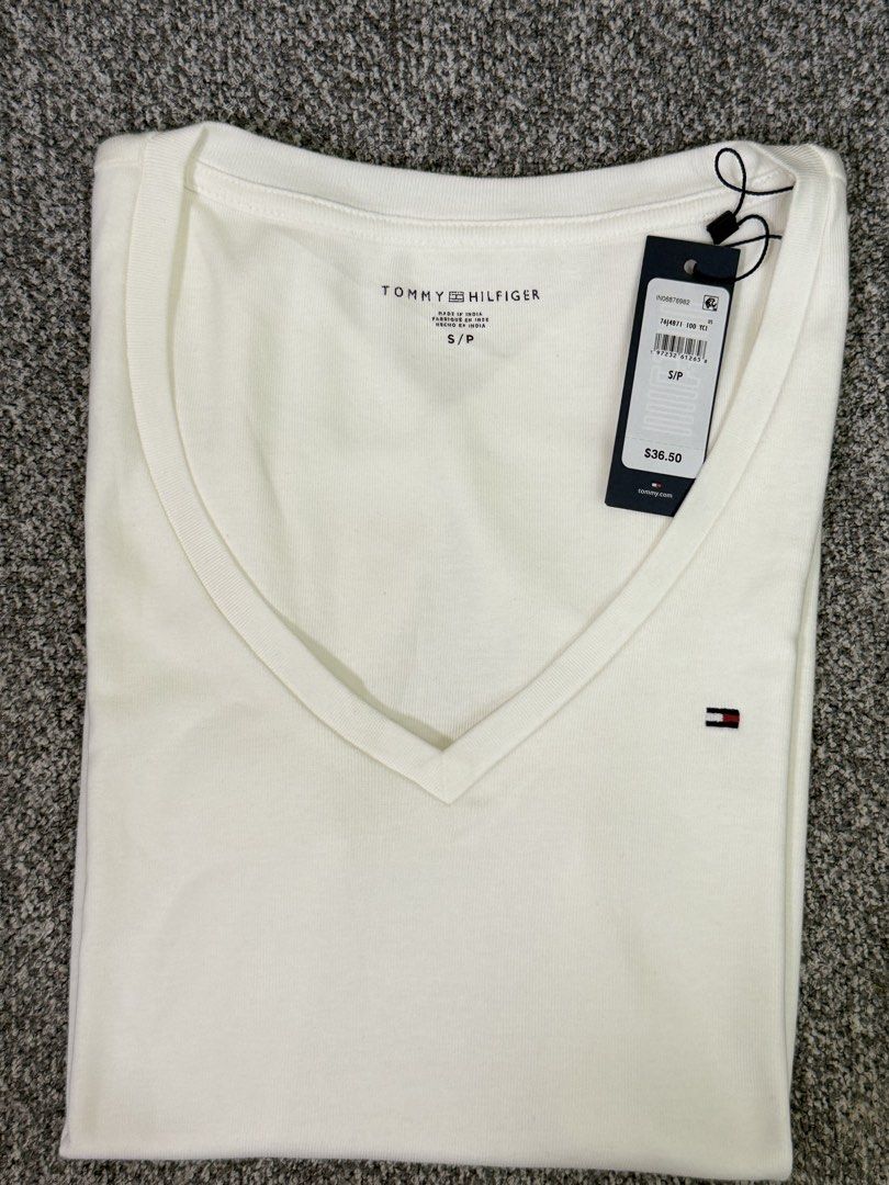 Tommy Hilfiger Basic White V-Neck T-Shirt (Category: Shirts) located in Pasig City. Submitted by shopwithelle__ (Listing ID 1460491024, Image 2). Description: - Classic white V-neck t-shirt - Brand: Tommy Hilfiger - Material: Soft cotton - Detail: Small logo on the chest - Size: S/P (Small/Petite) (fits upto med) - Versatile basic for any outfit.