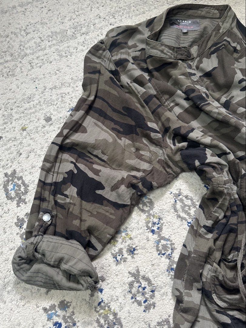 Torrid Green Camouflage Lightweight Utility Anorak Jacket (Category: Coats, Jackets and Outerwear) located in Daet. Submitted by thrifthings2018 (Listing ID 1460343892, Image 3). Description: - Torrid green camouflage utility/anorak jacket - Lightweight material - Adjustable drawstring waist - Button front closure - Two front pockets - Measurements: Width 28 inches, Length 33 inches - Ideal for casual wear.