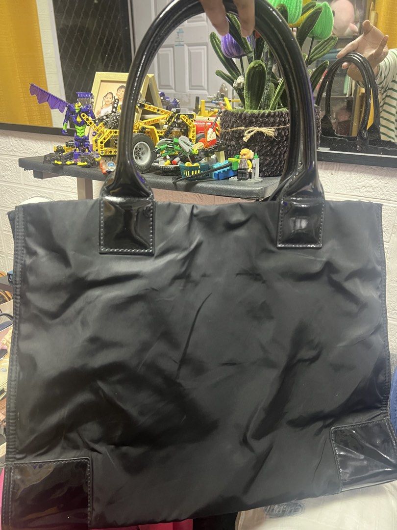Tory Burch Black Nylon Tote Bag (Category: Luxury Bags & Wallets) located in General Trias. Submitted by mybag2025 (Listing ID 1460473226, Image 2). Description: - Authentic Tory Burch tote bag in black. - Durable nylon material with elegant patent leather accents. - Iconic Tory Burch logo prominently displayed on the front. - Multiple interior compartments and a secure zip pocket for organization. - Zipper pull also features the Tory Burch logo.