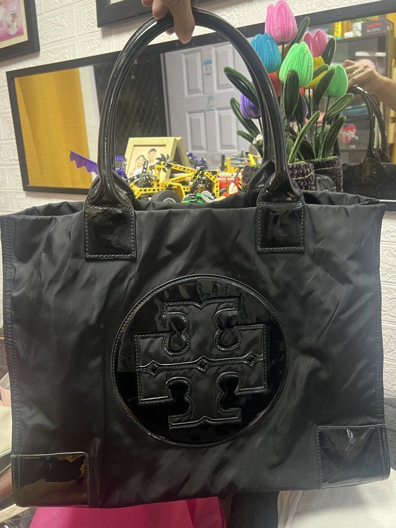 Tory Burch Black Nylon Tote Bag (Category: Luxury Bags & Wallets) located in General Trias. Submitted by mybag2025 (Listing ID 1460473226, Image 1). Description: - Authentic Tory Burch tote bag in black. - Durable nylon material with elegant patent leather accents. - Iconic Tory Burch logo prominently displayed on the front. - Multiple interior compartments and a secure zip pocket for organization. - Zipper pull also features the Tory Burch logo.