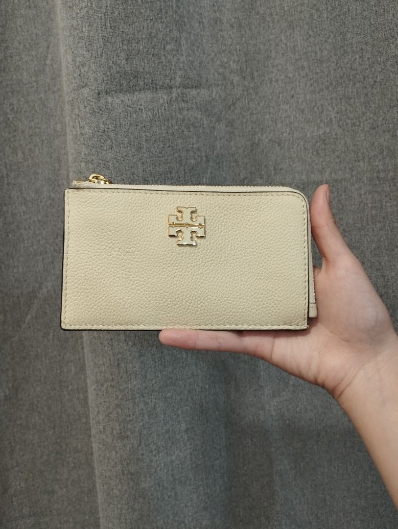 Tory Burch pebbled leather card holder wallet (Category: Wallets & Card holders) located in Caloocan City. Submitted by mkaelav (Listing ID 1460376989, Image 1). Description: - Cream colored Tory Burch card holder - Pebbled leather texture - Features a gold Tory Burch logo on the front - Secure zipper closure - Spacious enough for cards and some cash - Perfect for everyday use or travel.